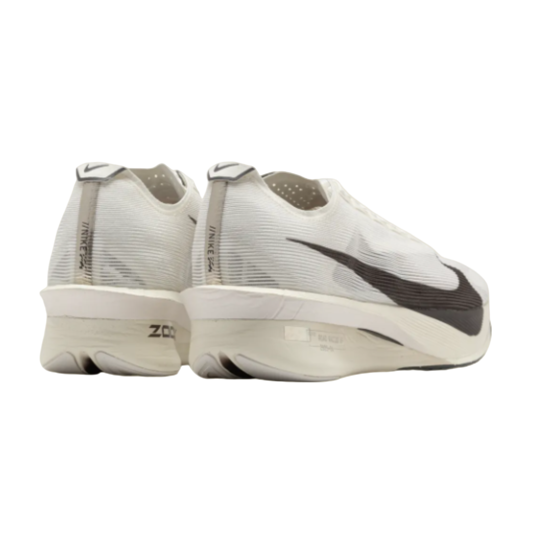 White running shoes with black swoosh logo on a beige background