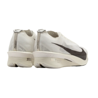 White running shoes with black swoosh logo on a beige background