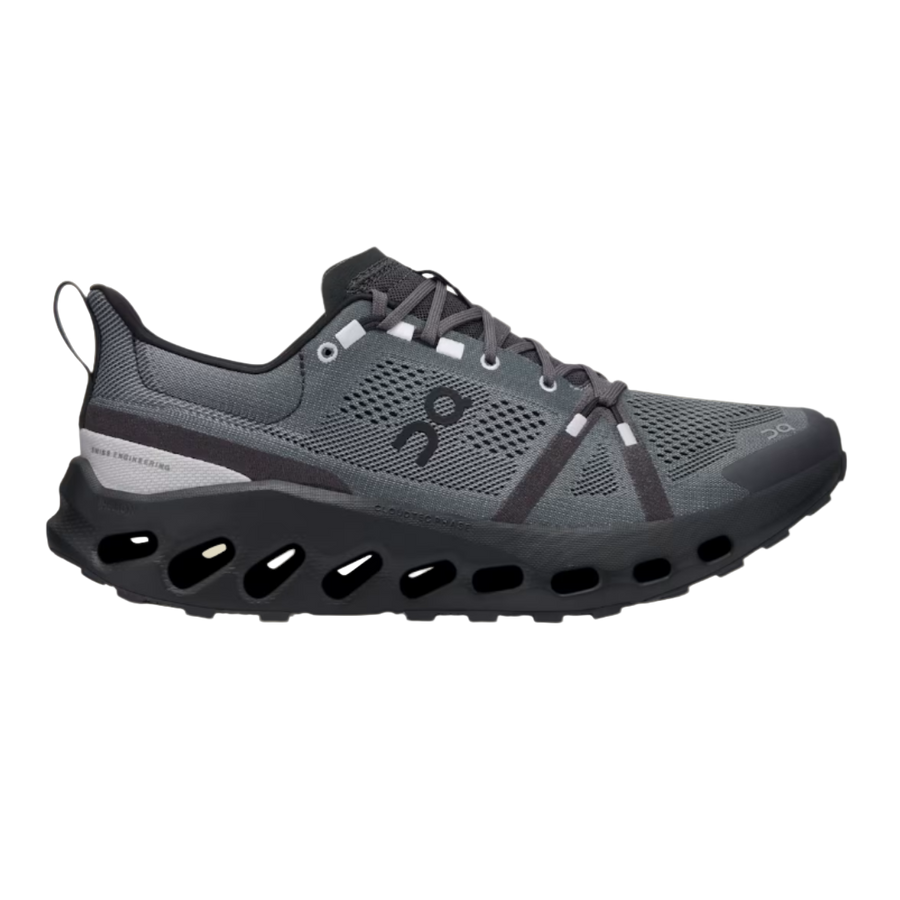 A trail running shoe with a flexible, soft-mesh upper and a shock-absorbing sole, predominantly in black color with gray elements.