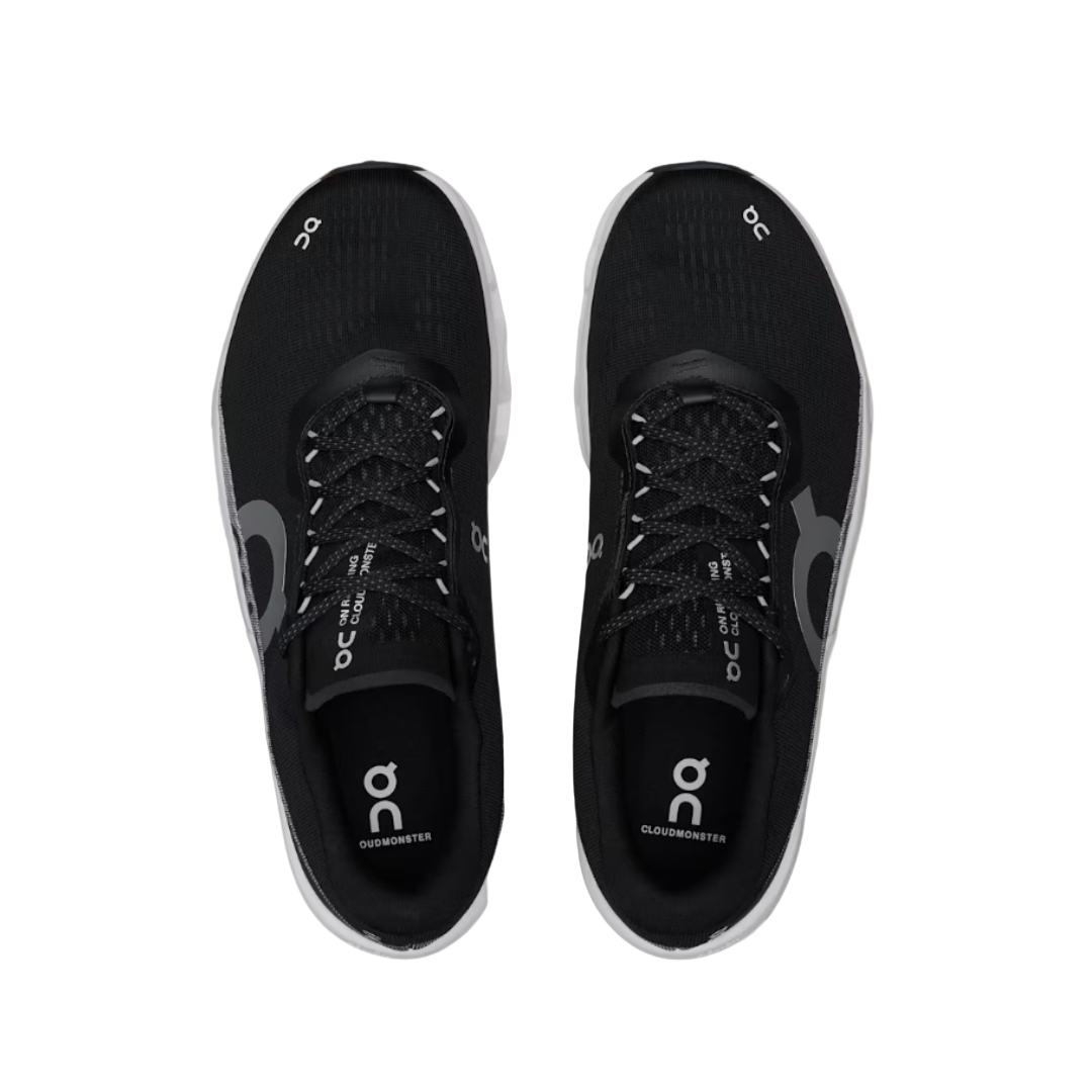 Black running shoes with 'On' branding on a beige background