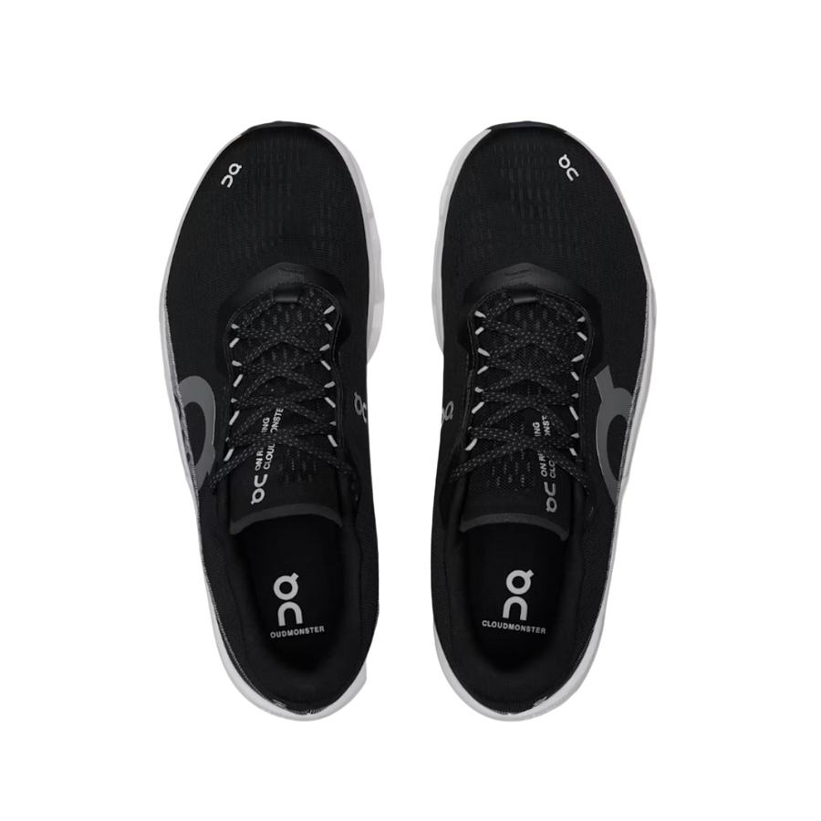 Black running shoes with 'On' branding on a beige background