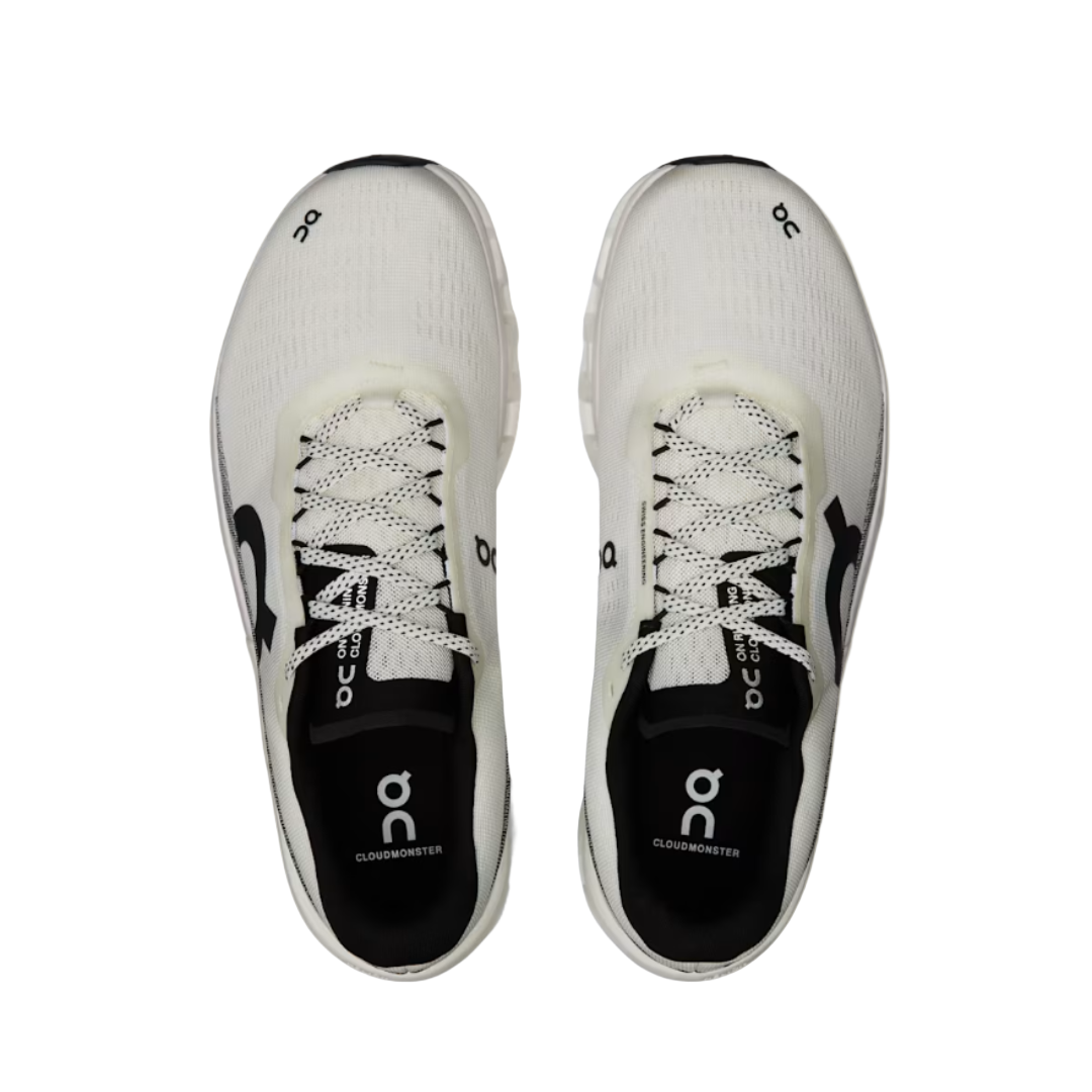 White running shoes with black soles on a beige background