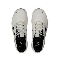 White running shoes with black soles on a beige background