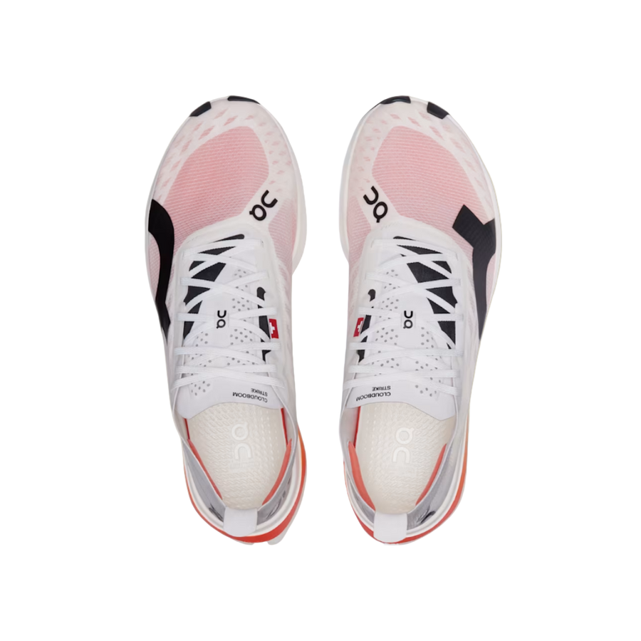 Pair of white sneakers with pink accents on a beige background